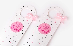 Detail of white gift tags with pink polka dots and silk bows featuring YOU are loved text