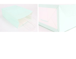 Detail van mintgroene papieren tas met witte handvatten en een stevige gevouwen bodem