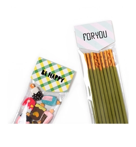 Detail of transparent treat bags with cute BE HAPPY card headers and ice cream charms