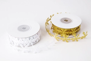 Detail of gold and white hollow snowflake ribbons for Christmas gift wrapping