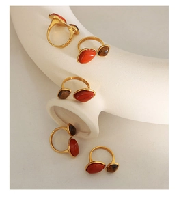 Detailed set of five vintage gold-plated rings featuring natural red stone and tiger eye