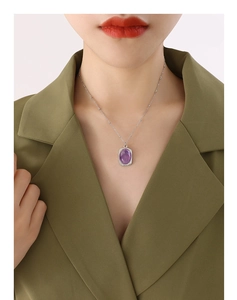 Close-up of vintage titanium steel necklace with a purple square pendant on a female model