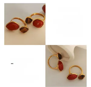 Detail of adjustable gold-plated ring featuring red stone and tiger eye stone settings