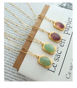 Detail of 18K gold plated square pendants with natural stones on elegant bead chains