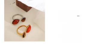 Close-up of gold-plated vintage ring featuring red agate and tiger eye stone inlay