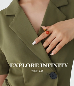 Detail of tiger eye and red agate double stone ring in gold on a model hand