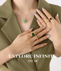 Detailed view of model wearing a gold square emerald pendant necklace and ring set