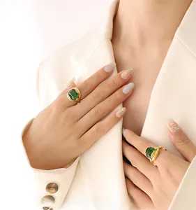 Close-up of vintage emerald cut green crystal rings on model with gold-plated bands