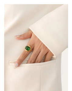 Detail of vintage gold plated ring with a large rectangular emerald green crystal stone