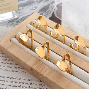 Abstract fluid gold rings on a wooden stand with elegant magazine background