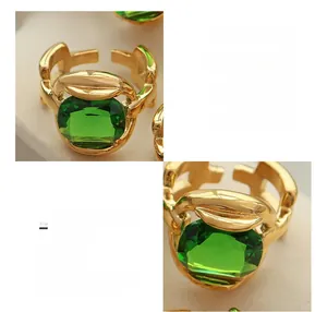 Detailed macro views showing emerald cut green crystal and 18K gold plated chain band ring