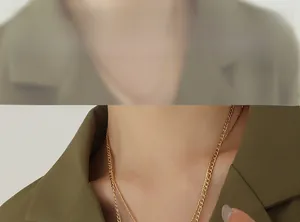 Detail of double-layer Figaro chain necklace in gold finish worn by a model