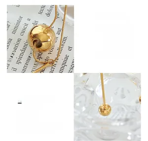 Detail of 18K gold plated titanium steel necklace with ball pendant and long tassels