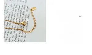 Detailed close-up of the K18 stamped gold necklace clasp and extender chain