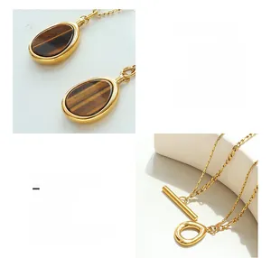 Detail of 18K gold plated titanium necklace with natural tiger eye stone and T-Bar clasp