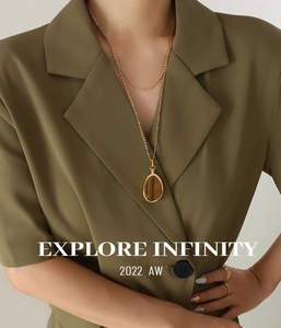Close-up of double-layer gold necklace with tiger eye stone pendant on model
