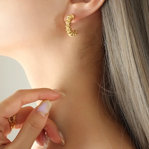 Golden C-shaped twisted croissant hoop earrings in minimalist vintage style for women