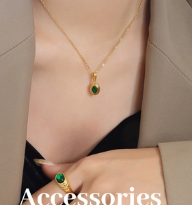 Macro shot of vintage gold-plated necklace and ring set with emerald green crystals