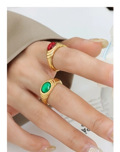 Detail of vintage gold textured rings with emerald and ruby zircon stones on a hand