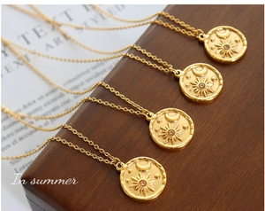Detail of four vintage gold plated celestial coin pendants with sun moon star and zircon