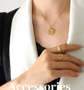 Elegant gold celestial necklace with sun moon pendant and rings set on a model in a suit