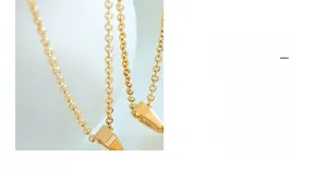 Detailed close-up of a polished gold-plated stainless steel chain and necklace clasp