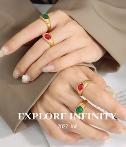 Close-up of vintage gold rings set with red and green gemstones and ribbed metal texture
