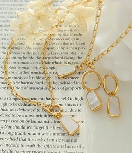 Detail of gold chain necklace with OT buckle and white shell pendant on vintage book