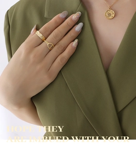Close-up of gold star and moon pendant necklace with wheat pattern rings on a model