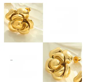 Macro detail of 18K gold-plated titanium steel earrings with layered camellia flower design