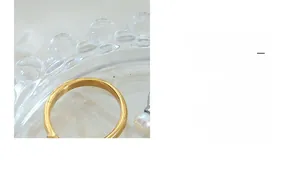 Detail of baroque freshwater pearl ring and U-shaped gold band on textured glass tray