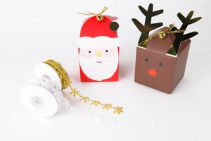 Detail of laser-cut snowflake ribbons in gold and white with Christmas gift boxes