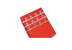 Close-up of metallic reindeer cutout ribbons in gold and silver on a red gift box