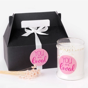 Pink round 'YOU are loved' stickers on a luxury scented candle gift box set