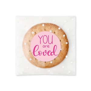 Pink heart sticker with 'YOU are loved' on a white polka dot butter cookie package