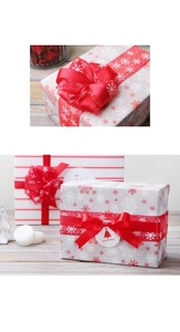 Close-up of Christmas snowflake sheer ribbon and red satin bow on festive gift box packaging