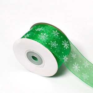Detail of green sheer organza ribbon with white snowflake prints for gift wrapping