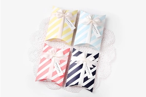 Detailansicht von Kissen-Geschenkboxen mit Streifenmuster und eleganten weißen Satinbändern