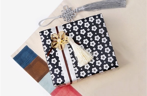 Elegante Geschenkbox mit Pflaumenblütenmuster, cremefarbenem Band und goldener Quaste