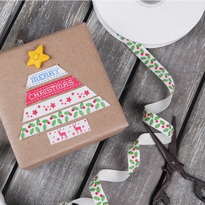 Close-up of 10mm cotton Christmas ribbon with red elk and stars on a gift box