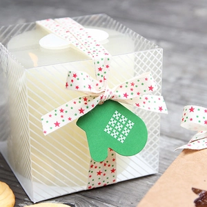 Christmas candle gift box with festive star pattern ribbon and a green glove tag