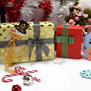 Premium Christmas gift boxes featuring gold polka dots and red-green festive ribbons