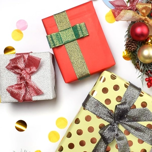 Three assorted premium holiday gift boxes with glitter ribbons and decorative sequins