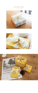 Nahaufnahme von gold bedruckten Weihnachtsbändern und schimmerndem Geschenkpapier