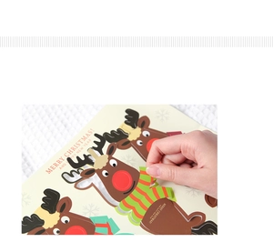 Detail of hand peeling reindeer lollipop decoration card with Merry Christmas text