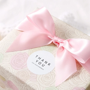 Elegant beige gift box with pink satin ribbon and circular Thank You For Your Kindness sticker