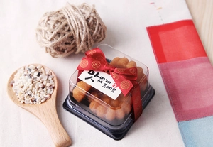 Detail of Korean Yakgwa gift box with red gold-stamped ribbon and greeting card