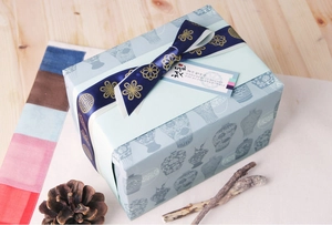 Close-up of a 25mm blue gold-stamped ribbon tied on a traditional gift box