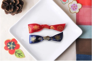 Close-up of handmade satin bow hair accessories with golden Japanese floral patterns
