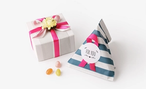 Close-up of elegant gift packaging with pink satin ribbons and a For You sticker